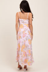 woman wearing a maternity floral maxi dress in pastel colors, showing the back view with a flowing silhouette