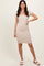 woman wearing a beige fitted dress with short sleeves and ruffled edges, styled with white slide sandals