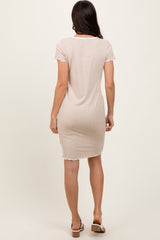 woman wearing a beige short sleeve ribbed dress with a fitted style and raw hem details, seen from the back