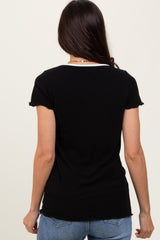 woman wearing a black ribbed short sleeve top, viewed from the back, paired with light blue jeans