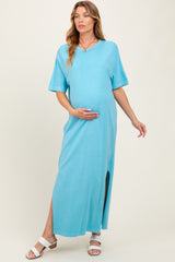 woman wearing a blue maternity maxi dress with short sleeves and a side slit, showing her baby bump