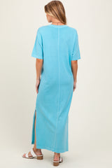 woman wearing a blue short sleeve maxi dress with side slits, shown from the back, maternity wear