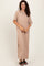 woman wearing a tan short sleeve maxi dress with a relaxed fit and side slits, standing and smiling