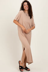 woman wearing a beige short sleeve maxi dress with side slits and standing in black sandals
