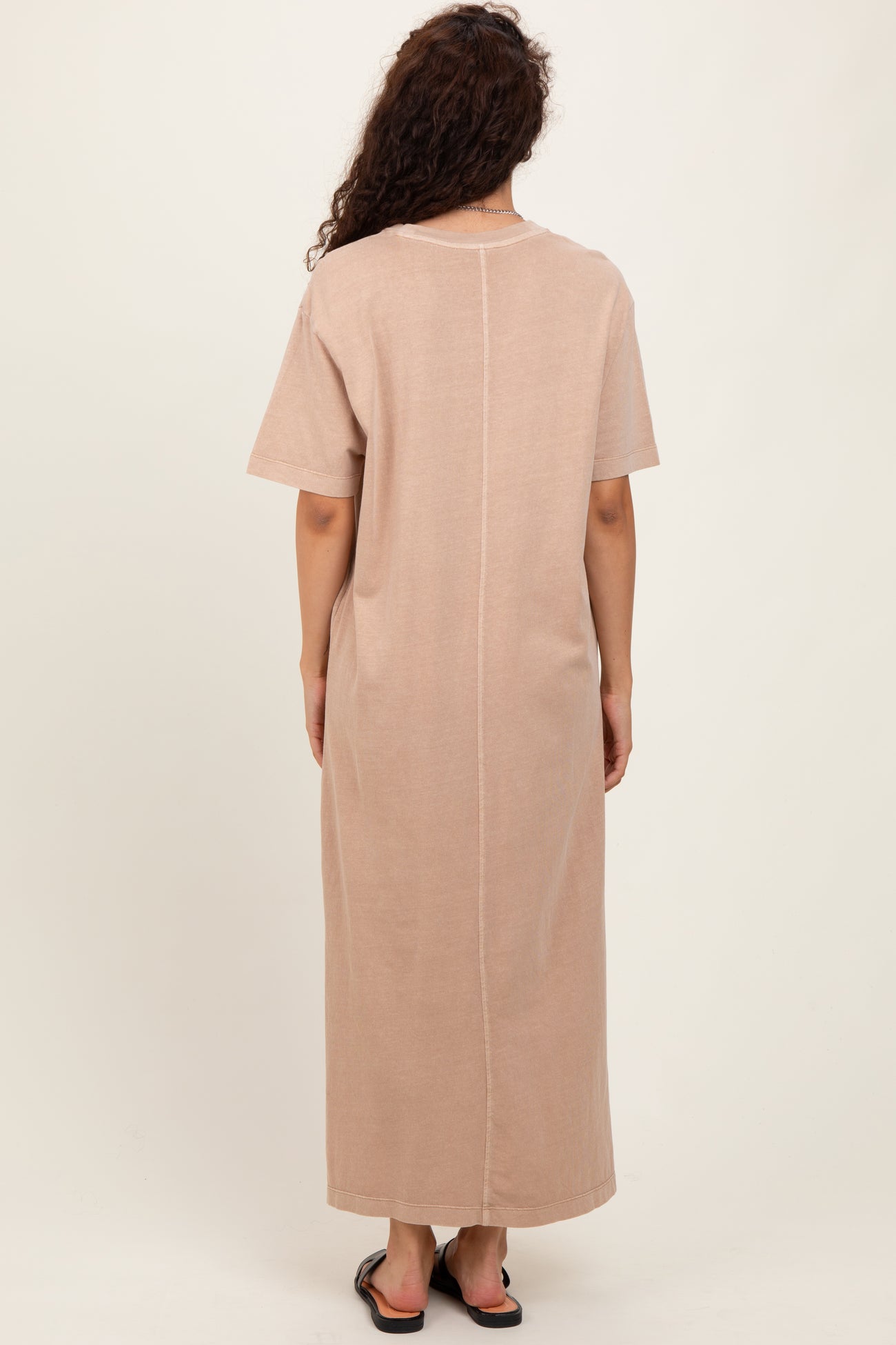 woman wearing a beige short sleeve maxi dress with a straight silhouette and back seam detail