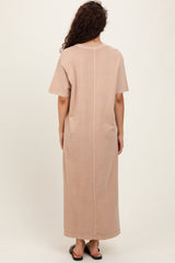 woman wearing a beige short sleeve maxi dress with a straight silhouette and back seam detail
