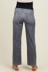 woman wearing grey maternity wide-leg jeans, seen from the back with a black waistband and casual sandals