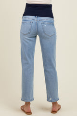 woman wearing light blue maternity jeans with a dark navy waistband and distressed details on the back