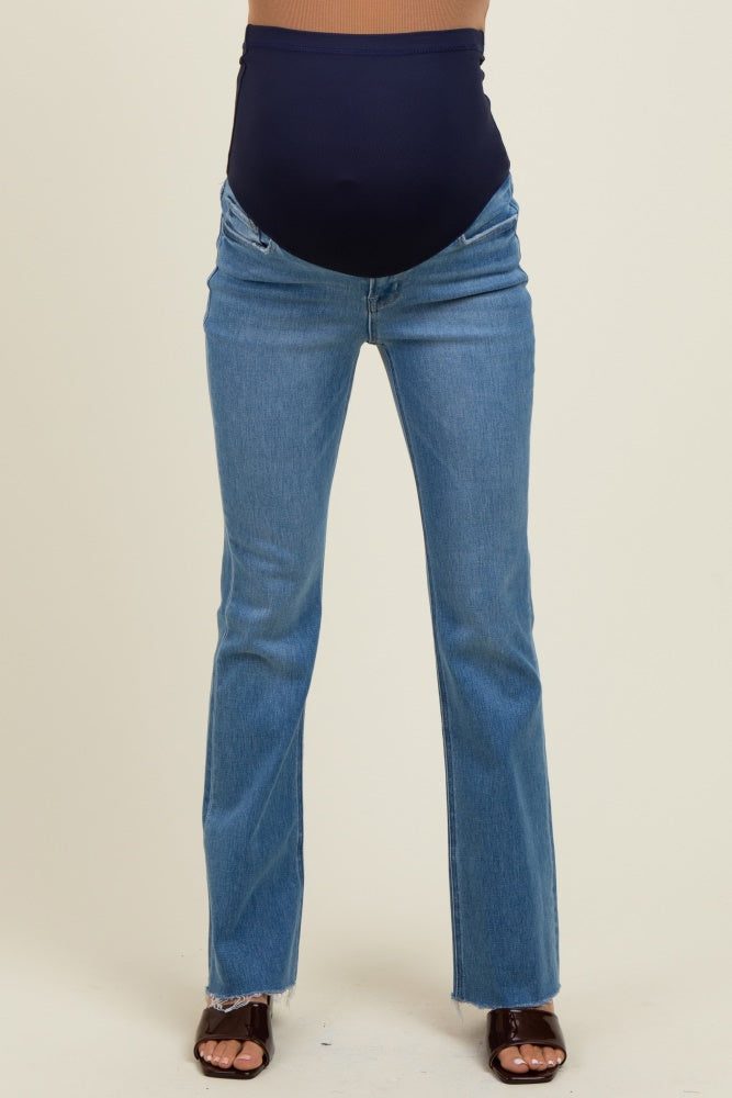 woman wearing blue maternity flared jeans with a dark blue over-the-bump panel and heeled sandals