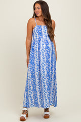 woman wearing a blue and white floral maternity maxi dress with spaghetti straps and flowing silhouette