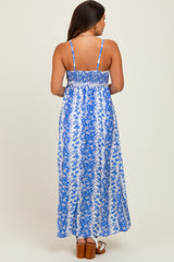woman wearing a blue floral maternity maxi dress with a smocked back and thin straps, showing her back