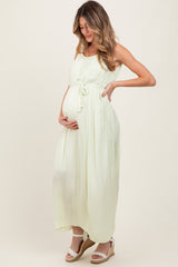 woman wearing a light yellow maternity maxi dress with a tied waist and a visible baby bump