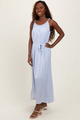 woman wearing a light blue maxi dress with a cinched waist and adjustable straps