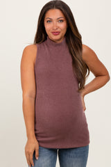 woman wearing a mauve sleeveless maternity top with a high neckline and a baby bump visible