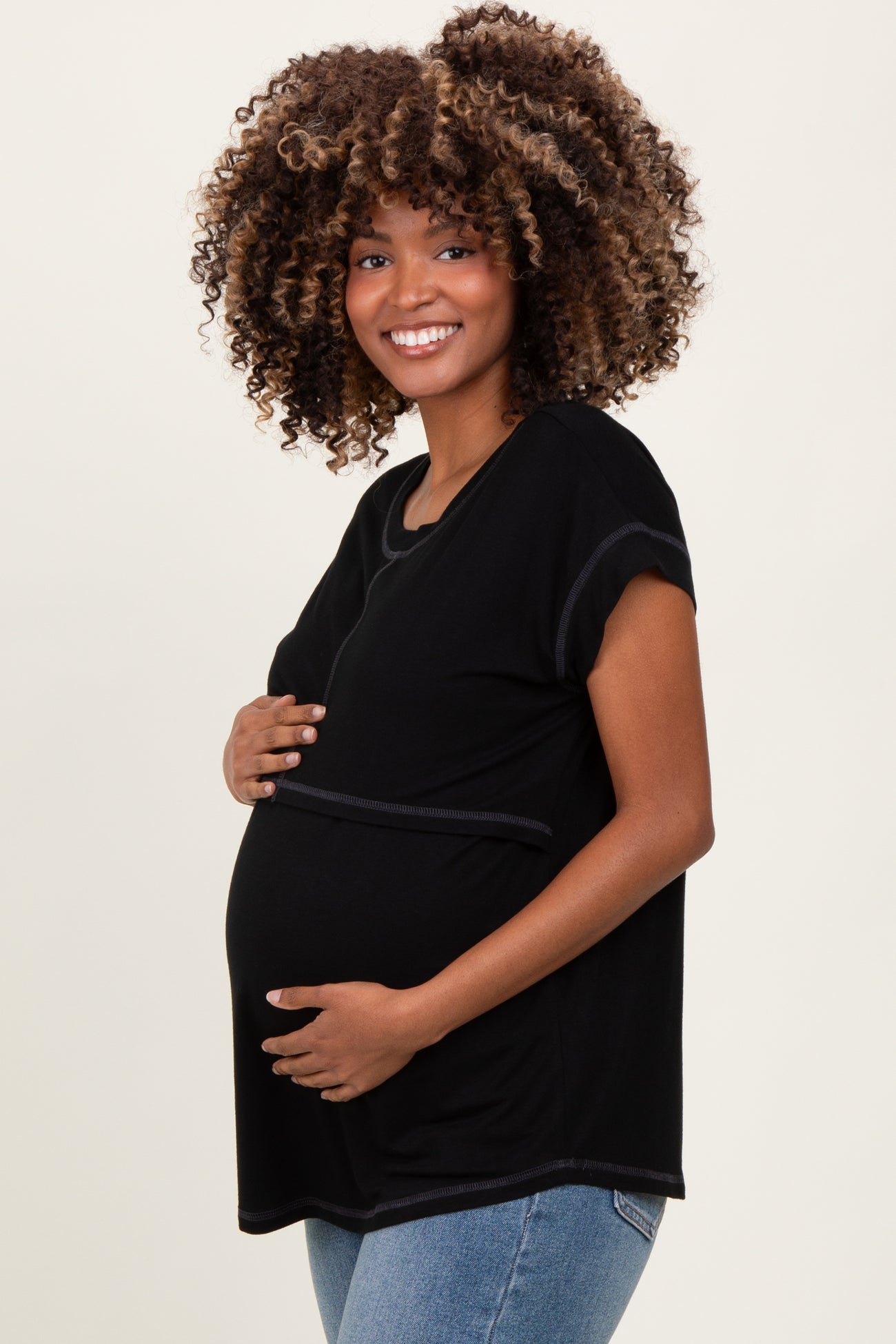 woman wearing a black short sleeve maternity top and showing her baby bump
