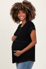 woman wearing a black short sleeve maternity top and showing her baby bump