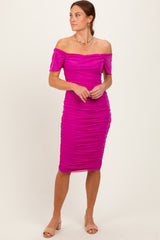 woman wearing a bright pink off-the-shoulder ruched midi dress with a fitted silhouette and short sleeves