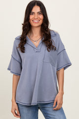 woman wearing a blue striped oversized short sleeve top with a v-neck and front pocket