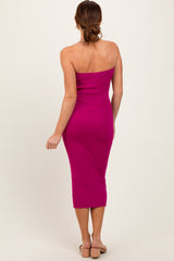 woman wearing a fitted fuchsia strapless midi dress, standing with her back to the camera
