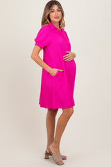 woman wearing a hot pink short sleeve maternity dress with pockets and holding her baby bump