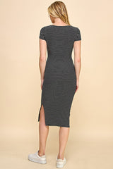 woman wearing a black and white striped midi dress with short sleeves and a side slit, photographed from the back