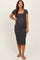 woman wearing a black and white striped maternity dress with a scoop neckline and short sleeves, showing her baby bump