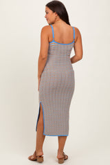 woman wearing a blue and orange striped maternity dress with side slits, view from the back