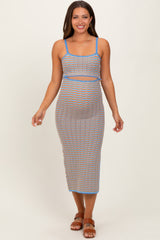 woman wearing a multicolored striped maternity dress with a fitted silhouette and spaghetti straps, showing her baby bump