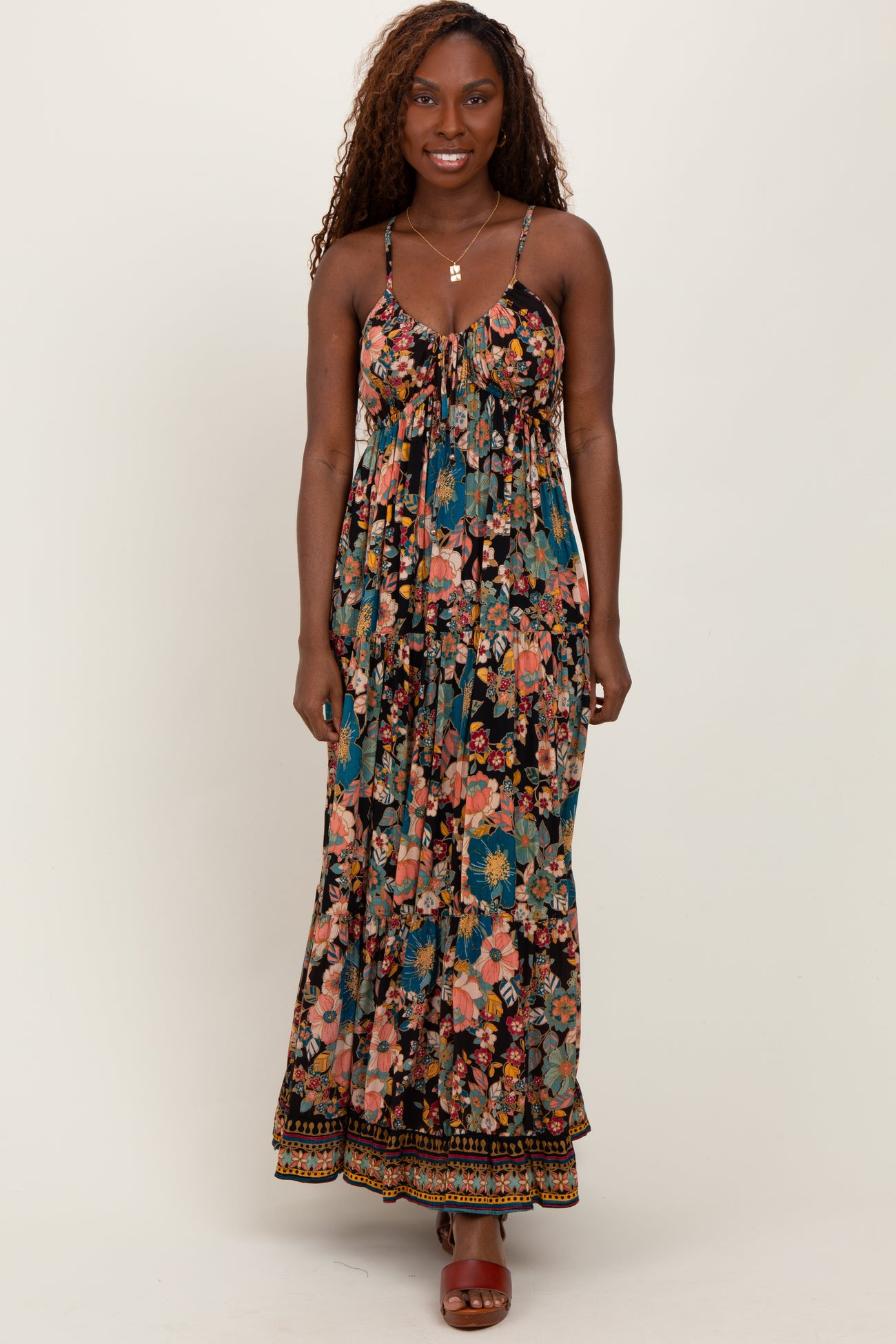 woman wearing a floral maxi dress with spaghetti straps and a flowing silhouette