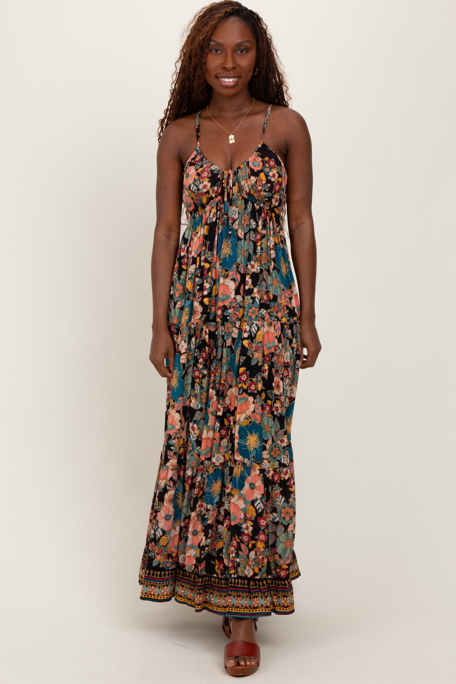 woman wearing a floral maxi dress with spaghetti straps and a flowing silhouette