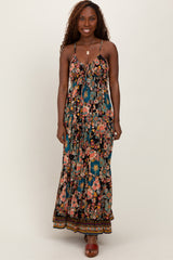 woman wearing a floral maxi dress with spaghetti straps and a flowing silhouette