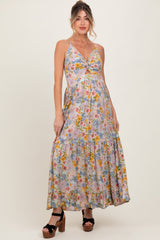 woman wearing a floral print maternity maxi dress with a twist front, showing a baby bump and wearing platform heels