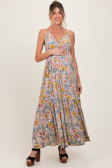 woman wearing a floral maternity maxi dress, showing her baby bump, with a fitted bodice and flowing skirt