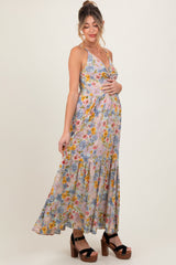 woman wearing a floral maxi maternity dress and holding her baby bump
