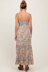 woman wearing a back view of a floral maternity maxi dress with adjustable straps and a smocked bodice