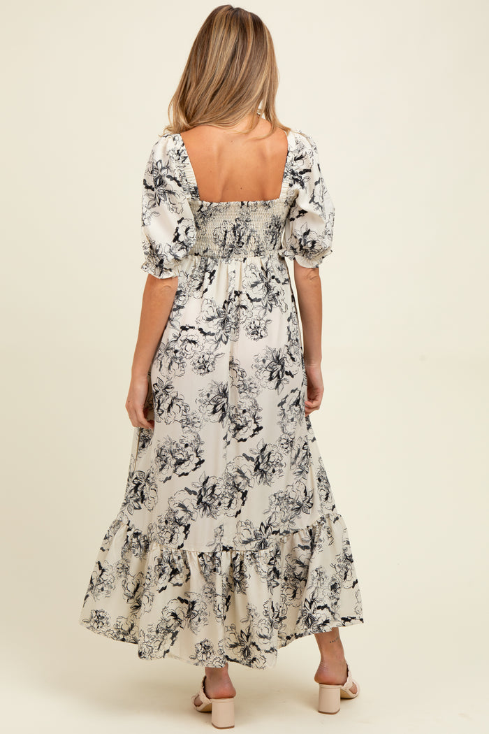 woman wearing a floral print maternity maxi dress with puffy sleeves and smocked back details