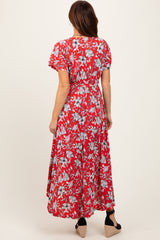 woman wearing a red floral maxi dress with short sleeves and a tie waist, viewed from the back