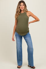 woman wearing a ribbed olive green maternity tank top and flared blue jeans, showing her baby bump
