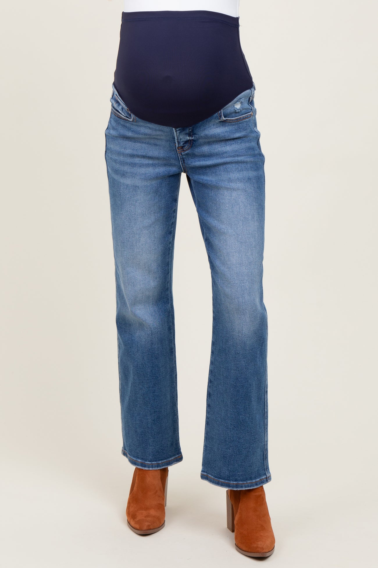 maternity wear blue flared jeans with a navy over-the-bump panel, model wearing brown heeled boots