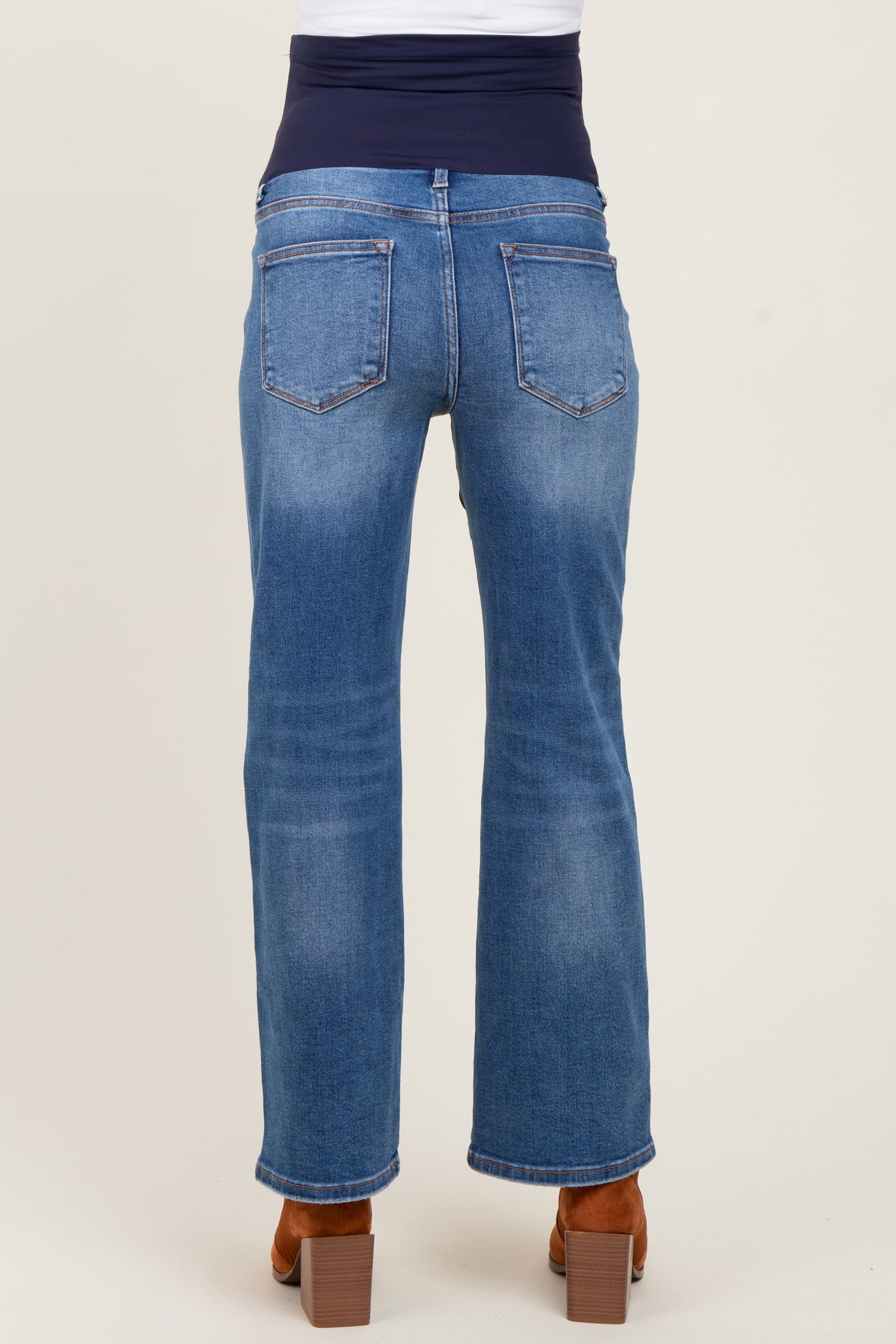 woman wearing blue maternity jeans with a stretchy navy waistband, viewed from the back