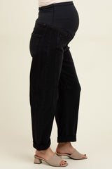 woman wearing black maternity jeans with a high waistband and a relaxed fit, showing a baby bump