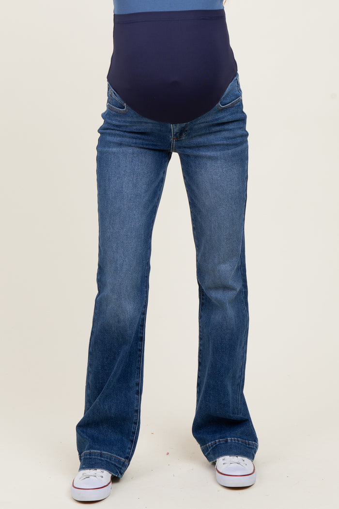 woman wearing a pair of blue maternity bootcut jeans with a supportive belly panel
