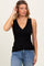 woman wearing a black v-neck ribbed tank top and blue jeans