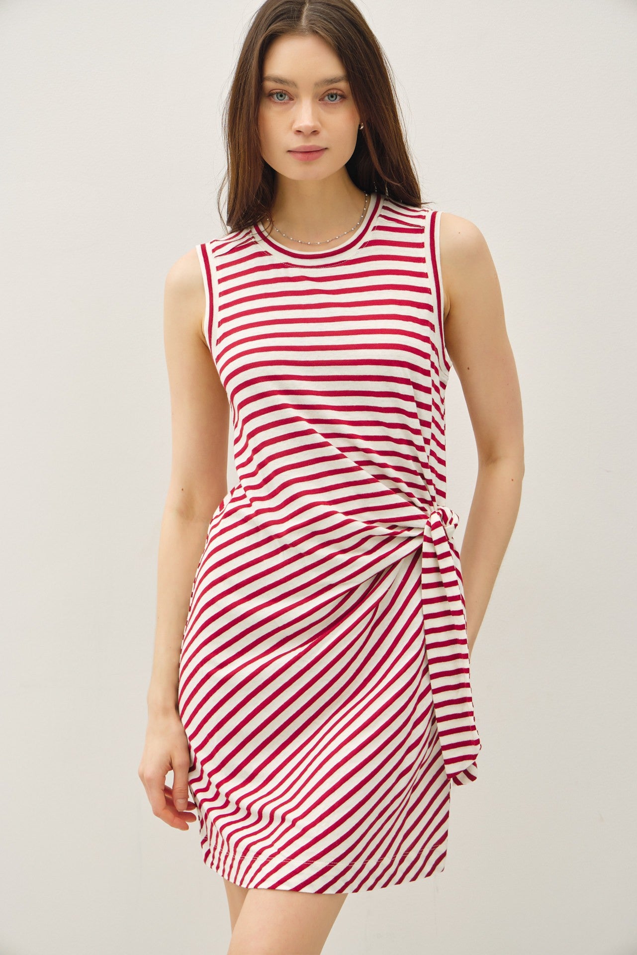 woman wearing a red and white striped sleeveless dress with a knot detail at the waist
