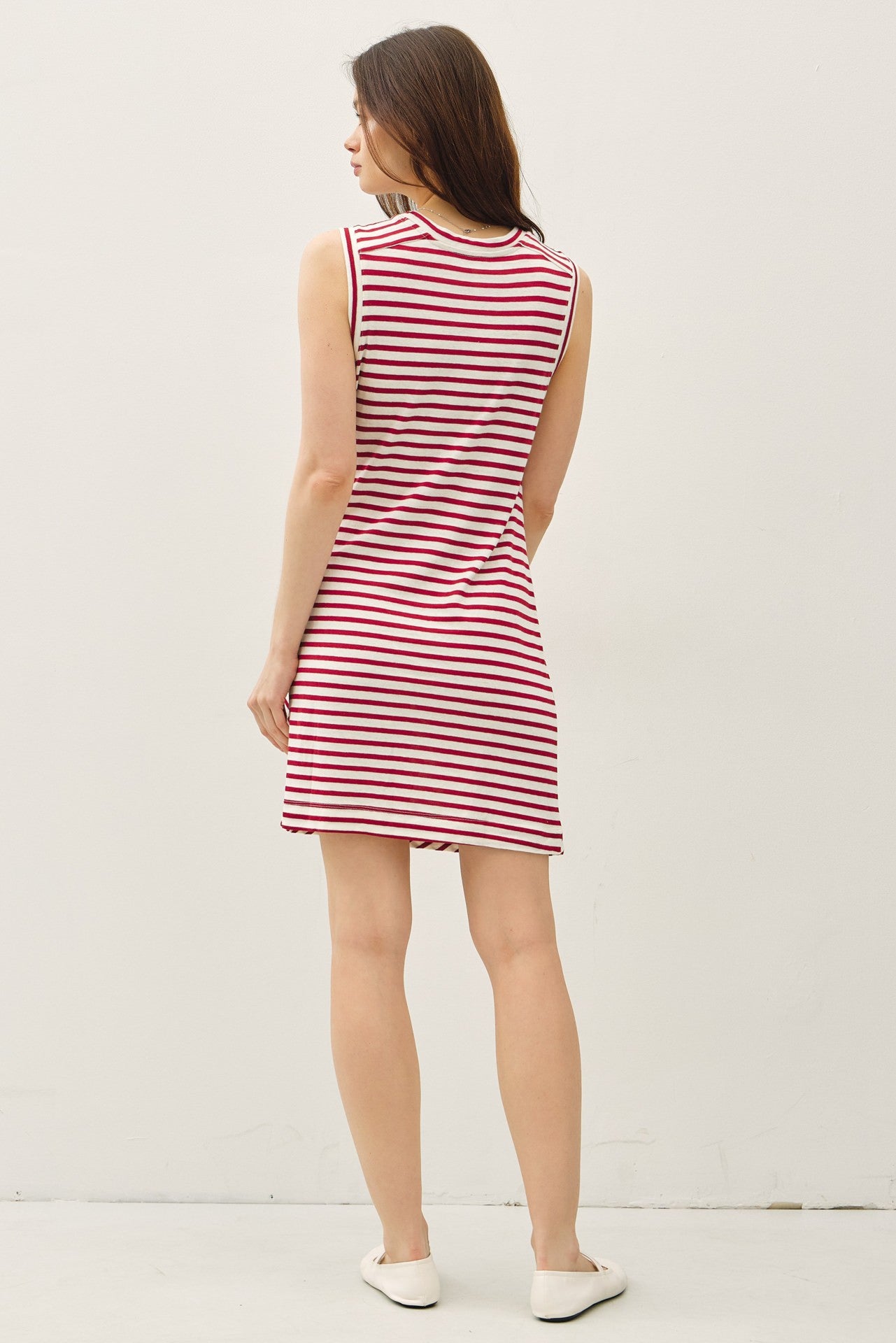 woman wearing a sleeveless red and white striped dress, viewed from the back