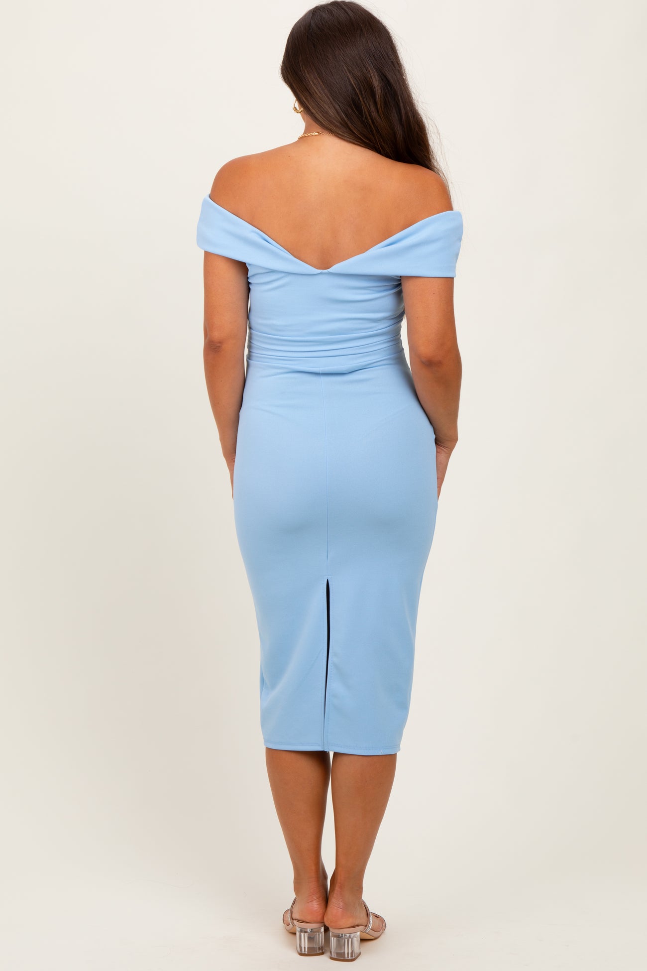 woman wearing a light blue off-the-shoulder maternity dress with a fitted silhouette and back slit