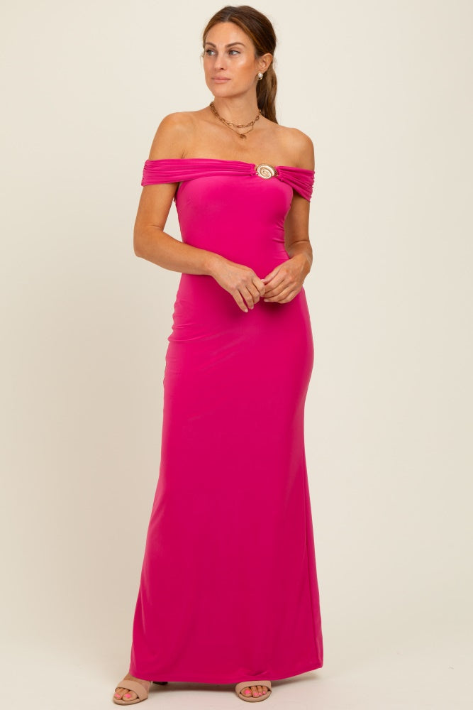 woman wearing a hot pink off-the-shoulder maxi dress with a decorative brooch detail