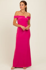 woman wearing a hot pink off-the-shoulder maxi dress with a decorative brooch detail