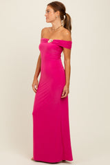 woman wearing a hot pink off-the-shoulder long dress with a decorative brooch on the side