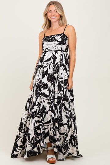 woman wearing a black and white floral maxi dress with a square neckline and spaghetti straps